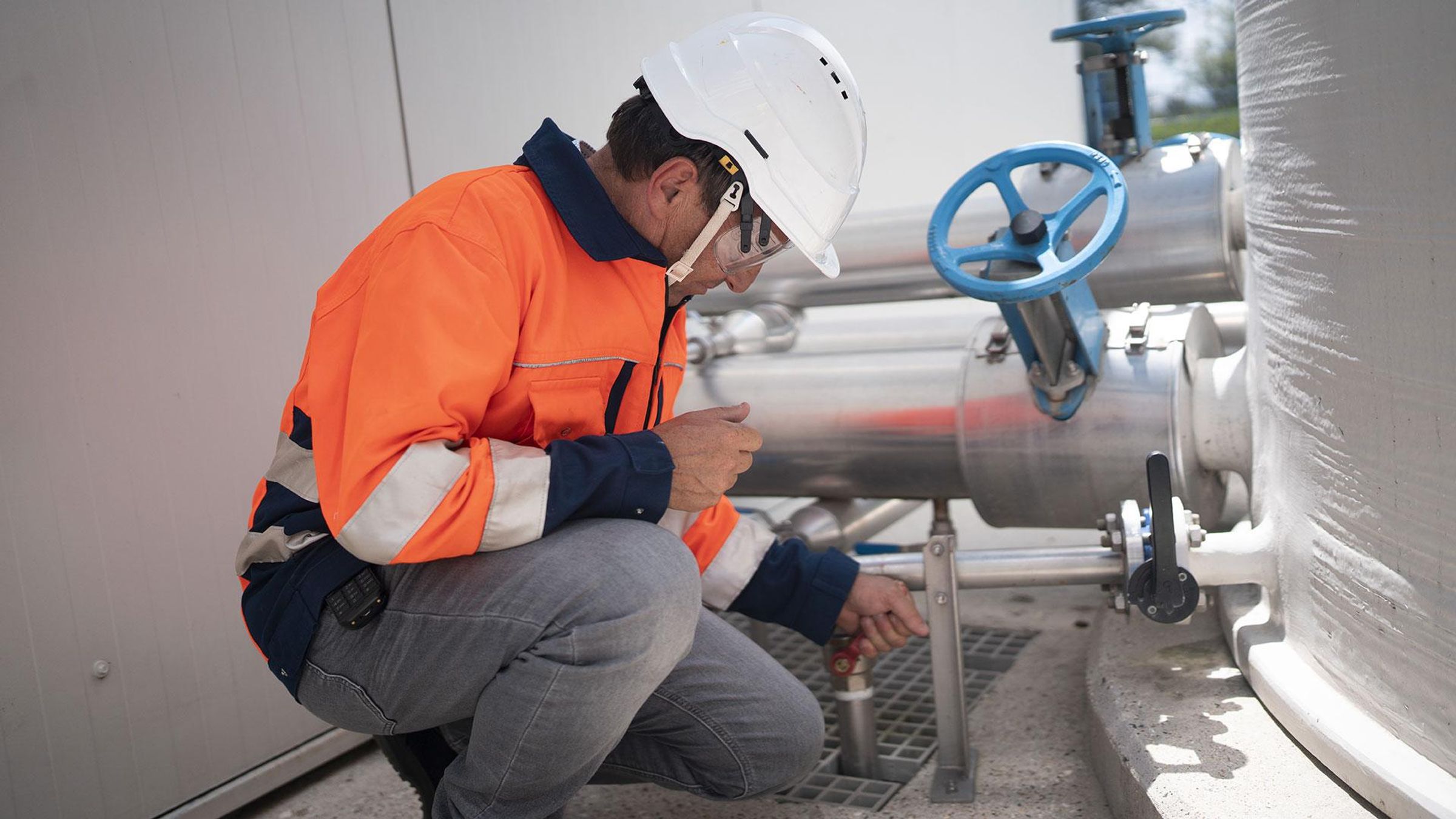 Marrick, en équipement de sécurité, actionne une vanne sur une canalisation de la station de traitement des eaux.