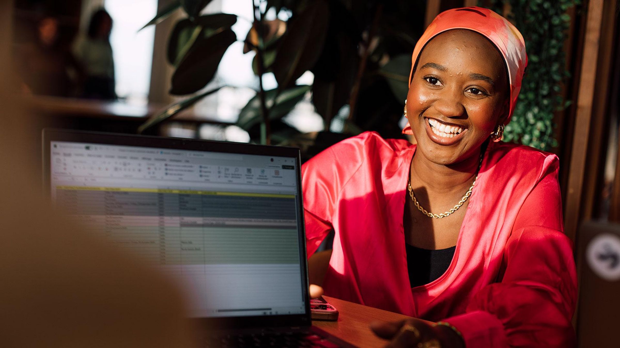 Rabiatou souriante en chemisier rouge et turban