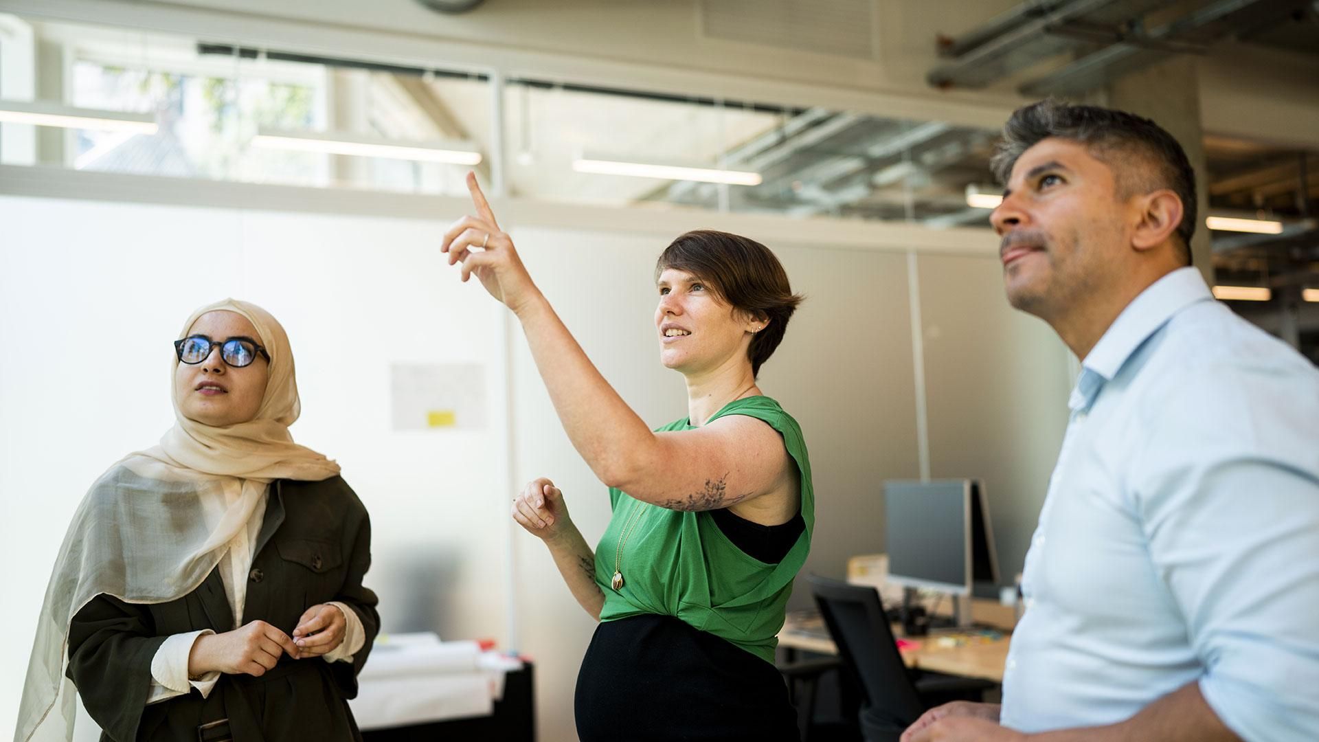 Amandine présentant un point à Zeinab et Richard lors d'une réunion agile.