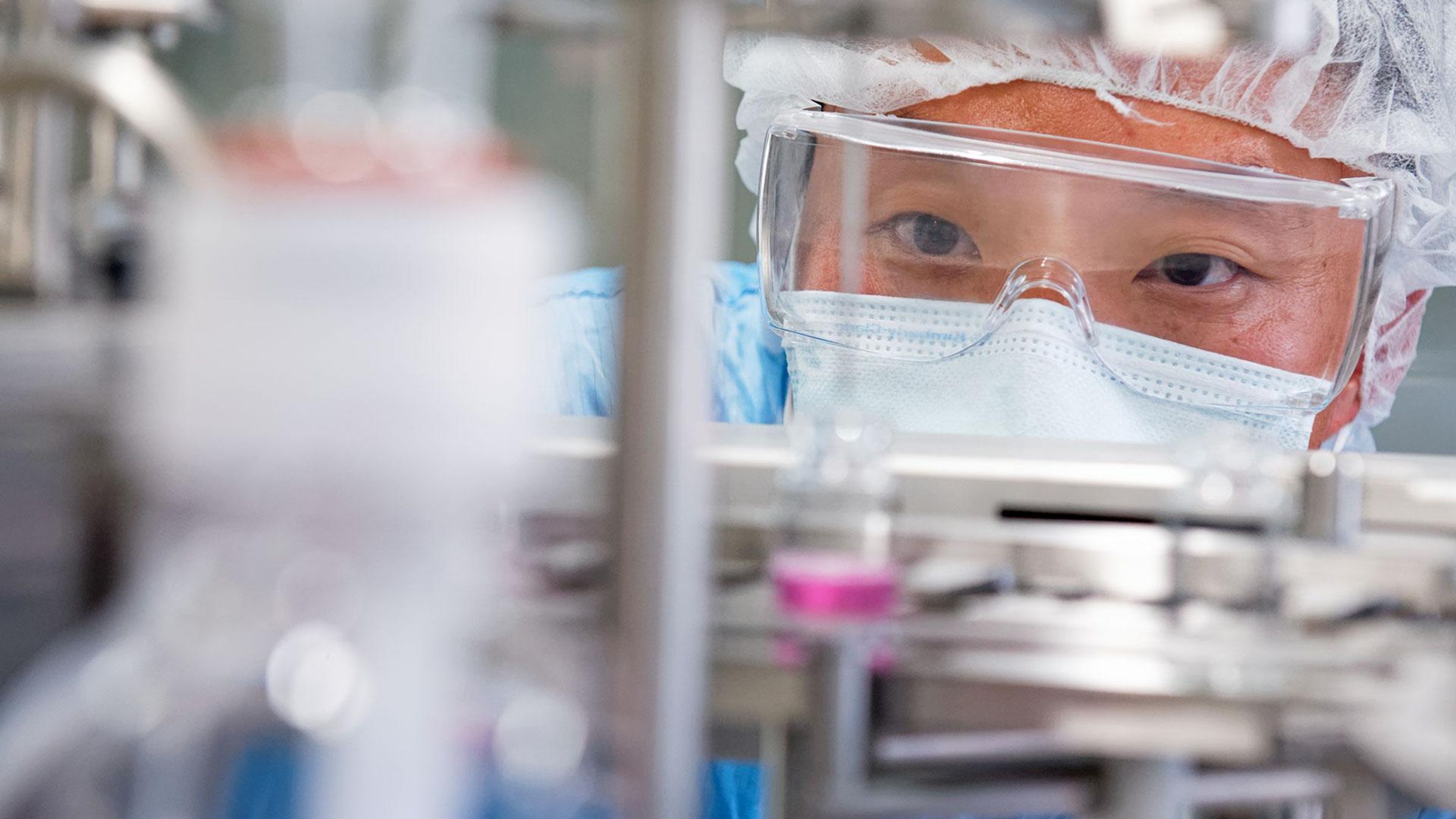 Scientifique en équipement de protection manipulant des instruments de laboratoire.