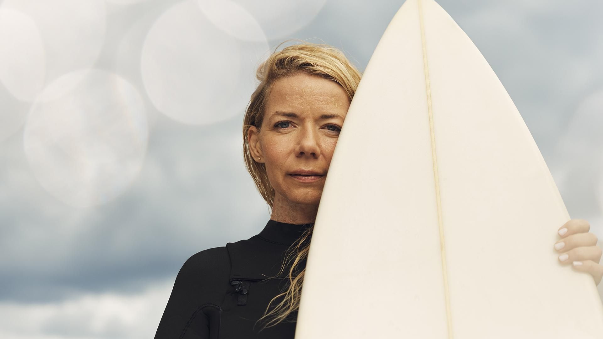 Céline portant sa planche de surf