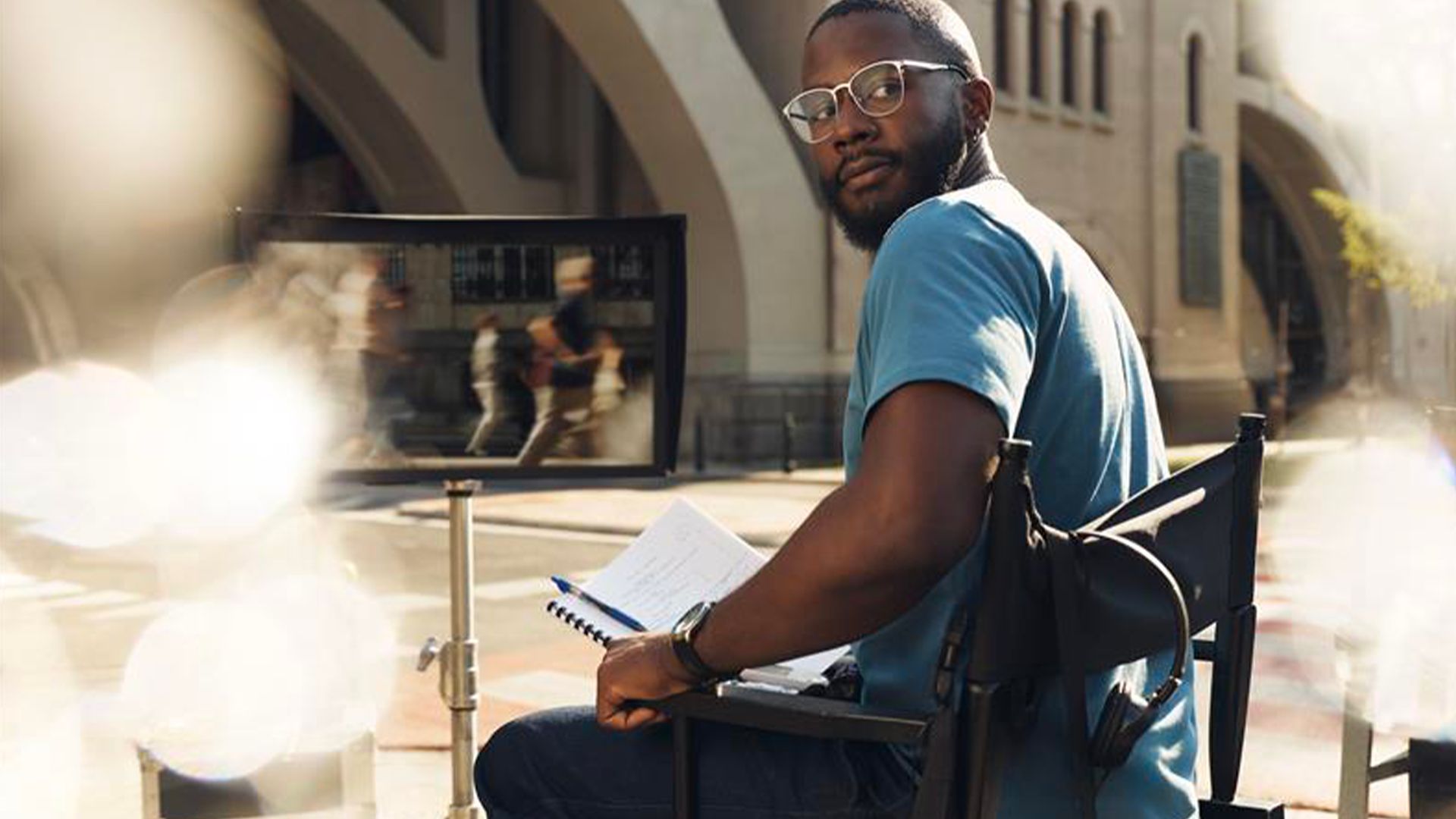 Xavier, patient diabétique de type 1, assis dans un fauteuil de réalisateur sur un plateau de tournage en extérieur